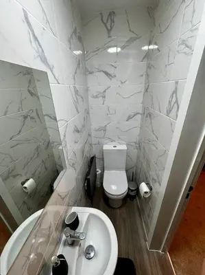 a white bathroom with a toilet and a sink at Stylish and Bright 1 Bedroom Flat in Wallasey