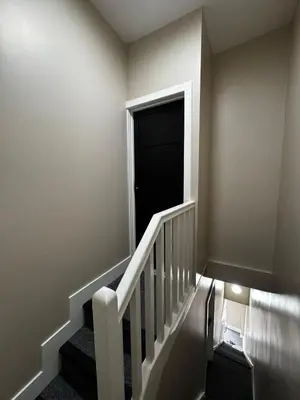 a stairway with a black door and a black door at Stylish and Bright 1 Bedroom Flat in Wallasey