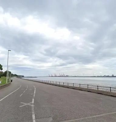 an empty road next to a body of water at Stylish and Bright 1 Bedroom Flat in Wallasey
