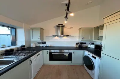 a kitchen with a sink and a stove top oven at City Centre Penthouse on Concert Square with City Views in Liverpool