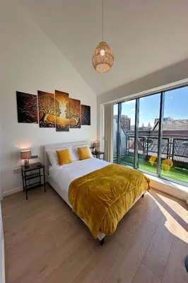 a bedroom with a large bed and a large window at City Centre Penthouse on Concert Square with City Views in Liverpool
