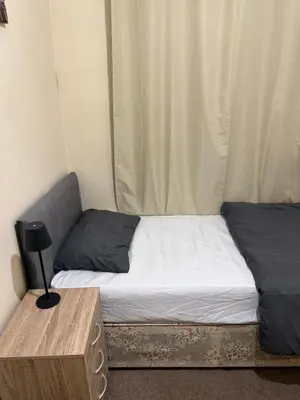 a small bedroom with a bed and a table at Room Near Anfield - Walk to the Stadium in Liverpool
