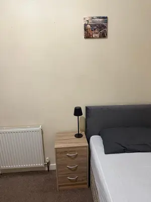 a bedroom with a bed and a nightstand with a lamp at Room Near Anfield - Walk to the Stadium in Liverpool