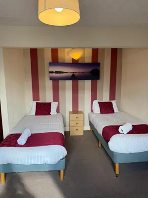 two beds in a room with red and white stripes at VERNON Hotel in Blackpool