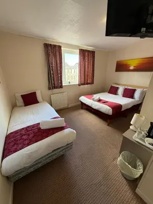 a hotel room with two beds and a window at VERNON Hotel in Blackpool