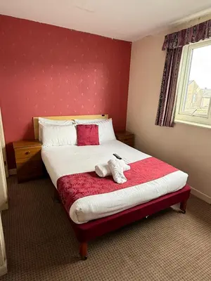 a bedroom with a bed with a stuffed animal on it at VERNON Hotel in Blackpool