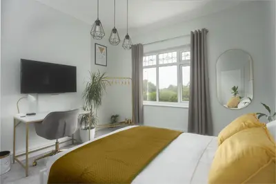 a bedroom with a bed and a desk and a mirror at Private room in a spacious home in Moreton
