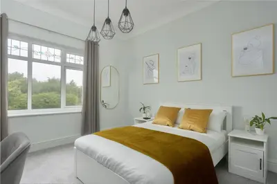 a white bedroom with a bed and a window at Private room in a spacious home in Moreton