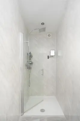 a shower with a glass door in a bathroom at Private room in a spacious home in Moreton