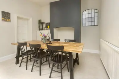 a dining room with a wooden table and chairs at Private room in a spacious home in Moreton