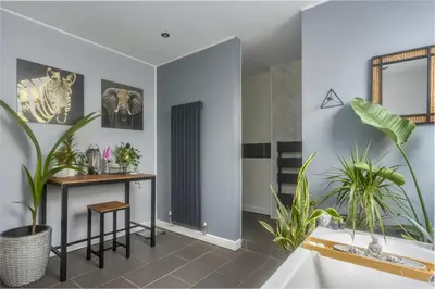 a bathroom with plants and a tub and a sink at Private room in a spacious home in Moreton