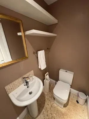 a bathroom with a sink and a toilet and a mirror at The Links House Lytham St Annes in Lytham St Annes