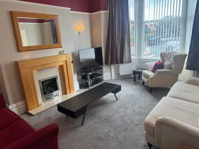 a living room with a fireplace and a tv at The Links House Lytham St Annes in Lytham St Annes