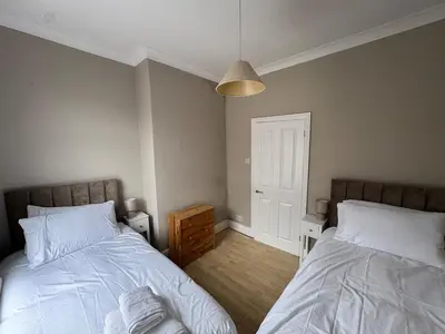 a bedroom with two beds and a lamp at The Links House Lytham St Annes in Lytham St Annes