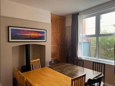 a dining room with a wooden table and a window at The Links House Lytham St Annes in Lytham St Annes