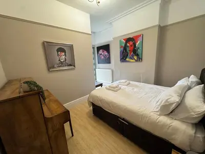 a bedroom with a bed and paintings on the wall at The Links House Lytham St Annes in Lytham St Annes