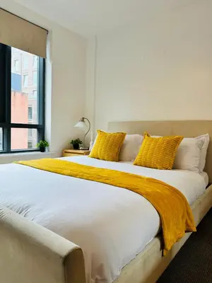 a bedroom with two beds with yellow pillows at City Centre Free Parking 2 Bedroom Apartment in Liverpool