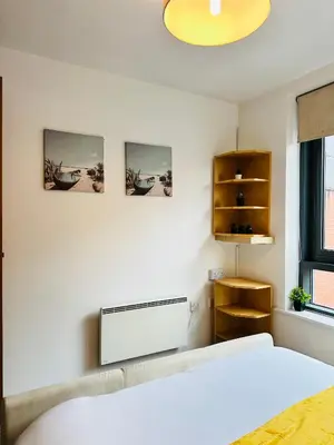 a bedroom with a bed and three pictures on the wall at City Centre Free Parking 2 Bedroom Apartment in Liverpool