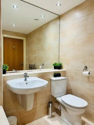 a bathroom with a sink and a toilet and a mirror at City Centre Free Parking 2 Bedroom Apartment in Liverpool