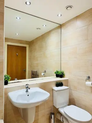 a bathroom with a sink and a toilet and a mirror at City Centre Free Parking 2 Bedroom Apartment in Liverpool