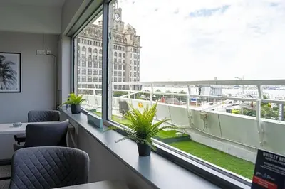 a room with chairs and a large window with plants at Atlantic Tower Liverpool City Center By Dancenter in Liverpool