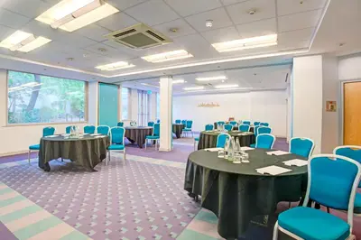 a conference room with tables and blue chairs at Atlantic Tower Liverpool City Center By Dancenter in Liverpool