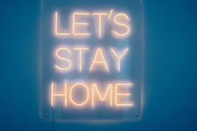 a neon sign that says lets stay home at Mersey View 4 Bedroom by Liverpoollux Next To Everton Stadium in Liverpool