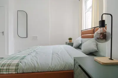 a bedroom with a bed and a desk with a lamp at Mersey View 4 Bedroom by Liverpoollux Next To Everton Stadium in Liverpool