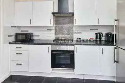 a kitchen with white cabinets and a black oven at Host & Stay - Bishop House in Liverpool