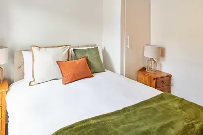 a bedroom with a white bed with green sheets and pillows at Host & Stay - Bishop House in Liverpool