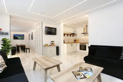 a living room with a black couch and a table at STAY BY THE SEA Deluxe Apartment in Blackpool