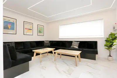 a living room with a black couch and a table at STAY BY THE SEA Deluxe Apartment in Blackpool