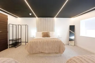 a bedroom with a large bed and a window at STAY BY THE SEA Deluxe Apartment in Blackpool
