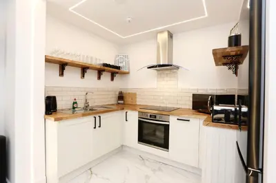 a kitchen with white cabinets and a stove top oven at STAY BY THE SEA Deluxe Apartment in Blackpool