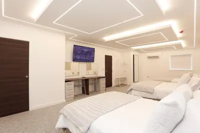 a white room with two beds and a desk at STAY BY THE SEA Deluxe Apartment in Blackpool