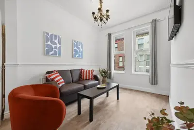 a living room with a couch and a table at Anfield Cozy House in Liverpool