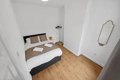 a bedroom with a bed in a white room at Anfield Cozy House in Liverpool