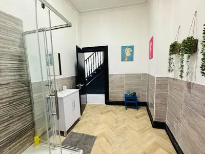 a bathroom with a shower and a blue chair at Pembroke Place Private Room 2B in Liverpool