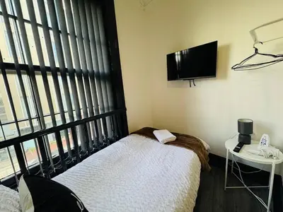 a room with two beds and a television on the wall at Pembroke Place Private Room 5B in Liverpool
