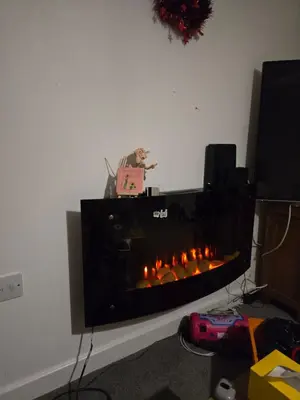 a man is standing in front of a fireplace at Belek villa Demiralp in Liverpool