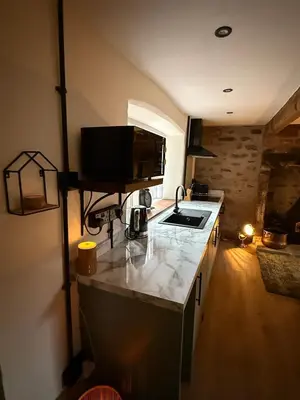 a kitchen with a sink and a counter top at The Snug- A beautiful and characterful property connected to a historic Georgian Manor House in Overton