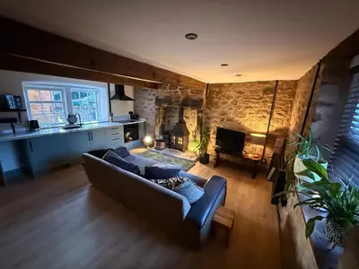 a living room with a couch and a fireplace at The Snug- A beautiful and characterful property connected to a historic Georgian Manor House in Overton