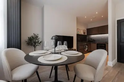 a dining room with a black table and chairs at Sunnie stays apartment harrington chambers in Liverpool