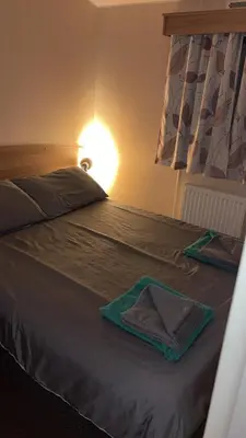 a bed with two towels sitting on top of it at Bills place in Heysham
