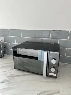 a microwave oven sitting on a counter in a kitchen at Chic 2 Apartment Family Home, Near Beach, WIFI, Sleeps 10 in Blackpool