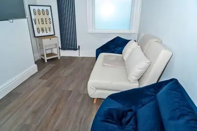 a living room with a white couch and a window at Chic 2 Apartment Family Home, Near Beach, WIFI, Sleeps 10 in Blackpool