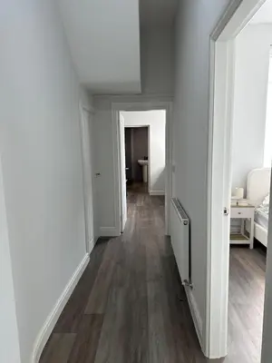 an empty hallway with white walls and wood floors at Chic 2 Apartment Family Home, Near Beach, WIFI, Sleeps 10 in Blackpool