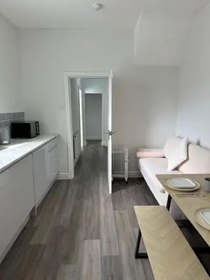 a white kitchen with a couch and a table at Chic 2 Apartment Family Home, Near Beach, WIFI, Sleeps 10 in Blackpool