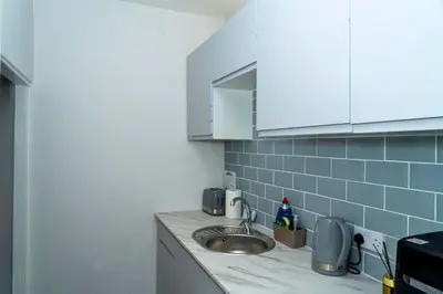 a kitchen with a sink and white cabinets at Chic 2 Apartment Family Home, Near Beach, WIFI, Sleeps 10 in Blackpool
