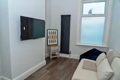 a living room with a couch and a flat screen tv at Chic 2 Apartment Family Home, Near Beach, WIFI, Sleeps 10 in Blackpool